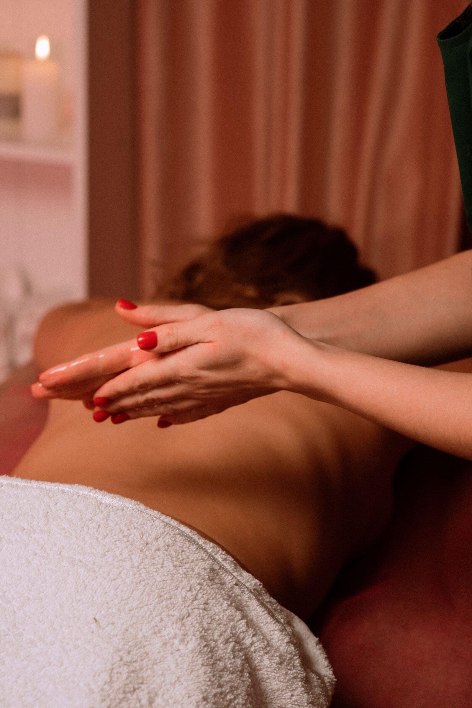 Close-up of a massage therapist's hands during a relaxing spa treatment session.