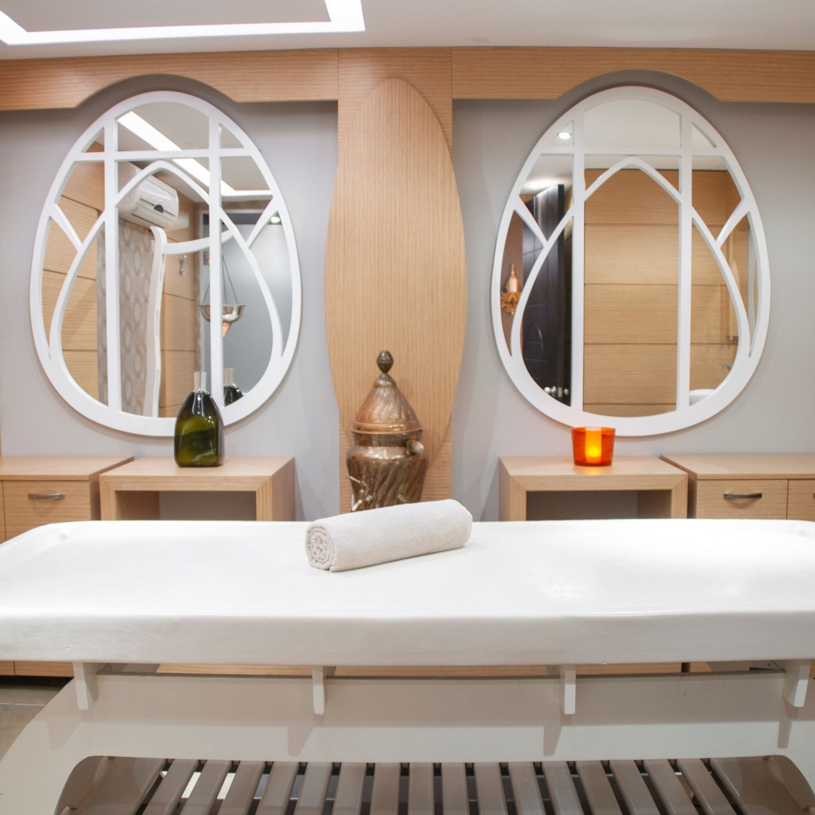 Elegant spa interior featuring a massage table and artistic mirrors, creating a relaxing atmosphere.
