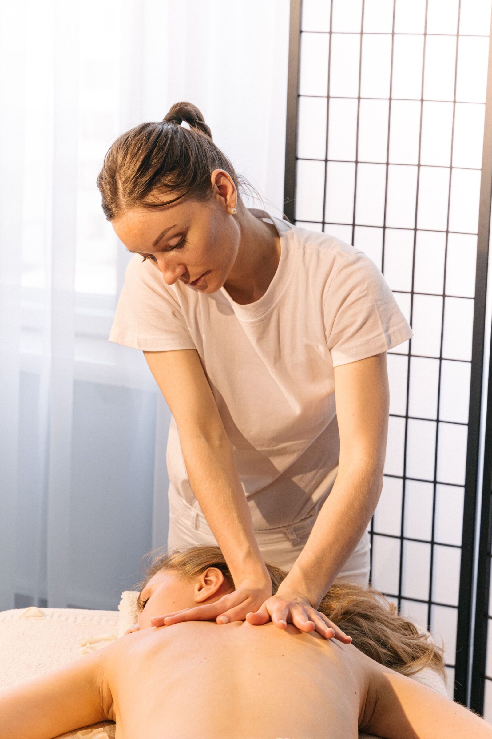 Experienced masseuse providing a relaxing back massage in a tranquil spa setting.