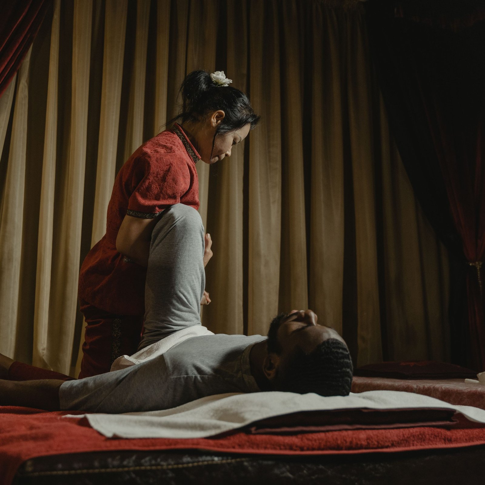 Therapist performing a leg stretch on client in a serene spa setting, promoting relaxation and wellness.