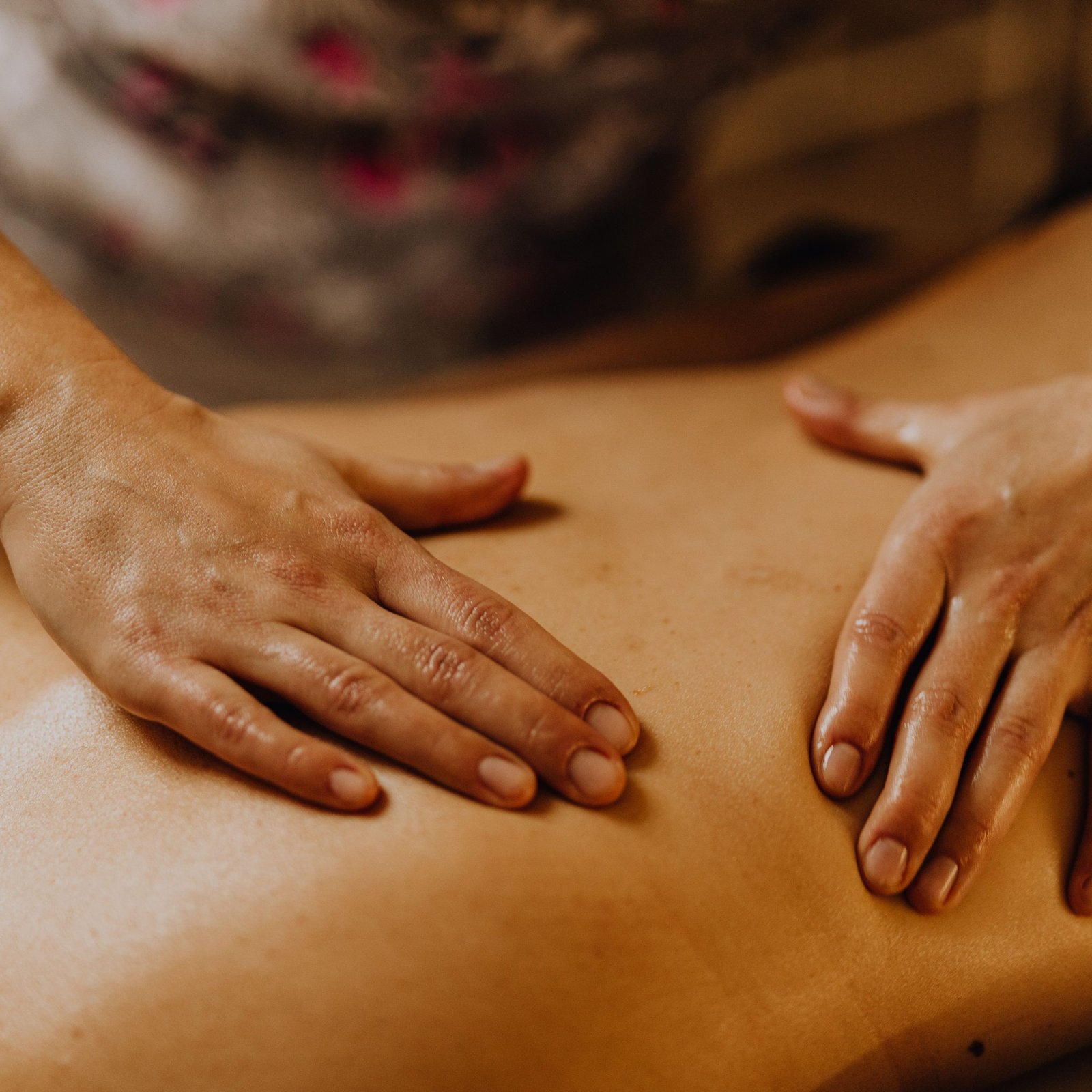 Close-up of hands giving a soothing back massage in a calm setting.
